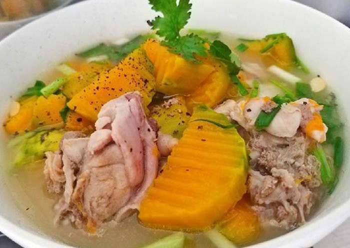 Bát canh bí đỏ ấm nóng trên bàn ăn