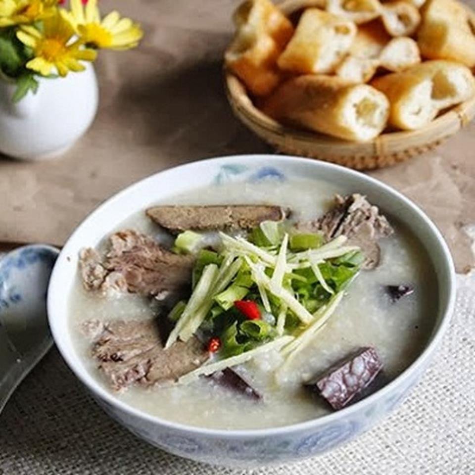 Bát cháo lòng hoàn chỉnh với rau thơm, tiêu và lòng dồi đa dạng.