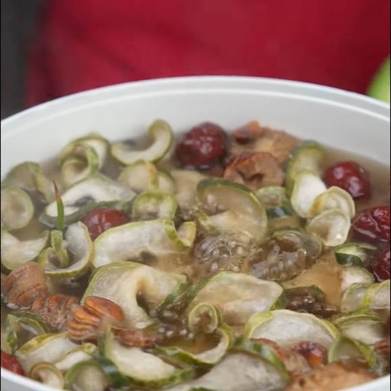 Bí đao khô, táo đỏ, la hán quả và mía nướng đang được nấu trong nồi nhôm lớn