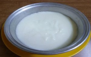 Bột bánh đúc mặn được dàn đều trong khuôn trước khi hấp, một bước quan trọng trong cách làm bánh mặn miền Tây.