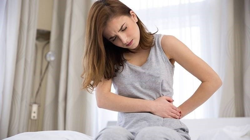 Bụng khó chịu và cà rốt, thể hiện nguy cơ rối loạn tiêu hóa như táo bón khi ăn quá nhiều cà rốt.