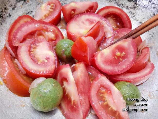 Cà chua đang được xào trên chảo, bước chuẩn bị nước dùng cho cách nấu bún giò heo cà chua