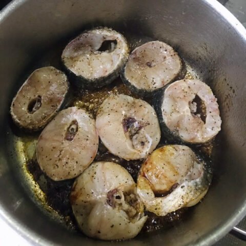 Cá lóc đang được đảo đều trong nồi cùng nước màu và gia vị