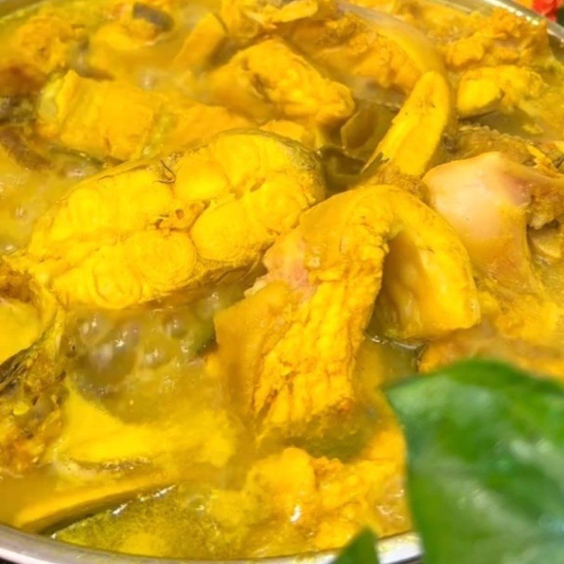 Cá ngạnh đang om trong nồi với chuối xanh và đậu phụ