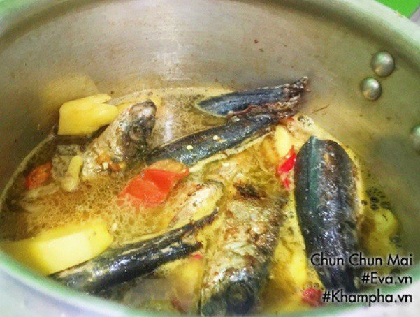 Cá nục đang được kho trong nồi, nước sốt ngập mặt cá giúp thấm vị đều.