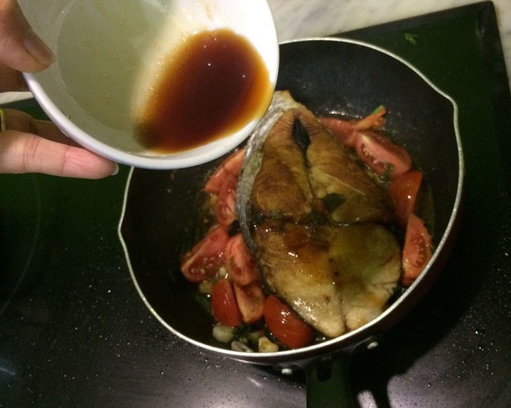 Cá thu tươi đang được sốt cùng cà chua trên bếp