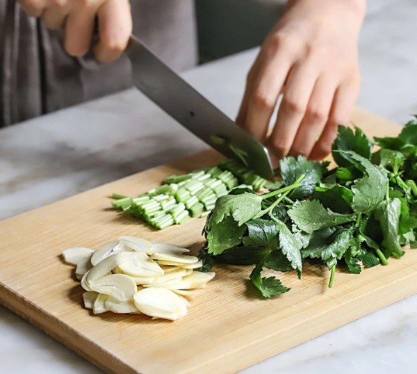 Cần tây thái khúc và tỏi băm nhỏ, những nguyên liệu tươi ngon cho món mì xào bò Hàn Quốc