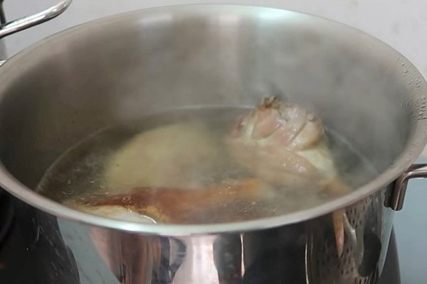Chần vịt đã chiên qua nước sôi để loại bỏ dầu thừa trong cách nấu mì vịt tiềm