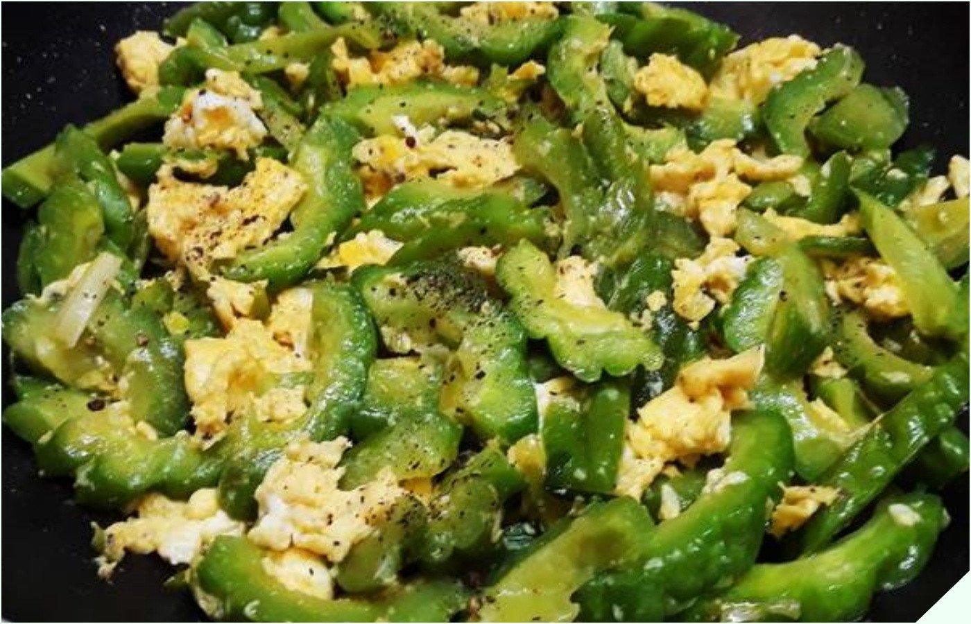 Chảo khổ qua và cà rốt đang được xào cùng trứng gà