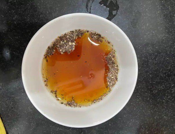 Chảo mực nhồi thịt đang được rim với nước mắm, tạo màu vàng nâu óng ánh hấp dẫn