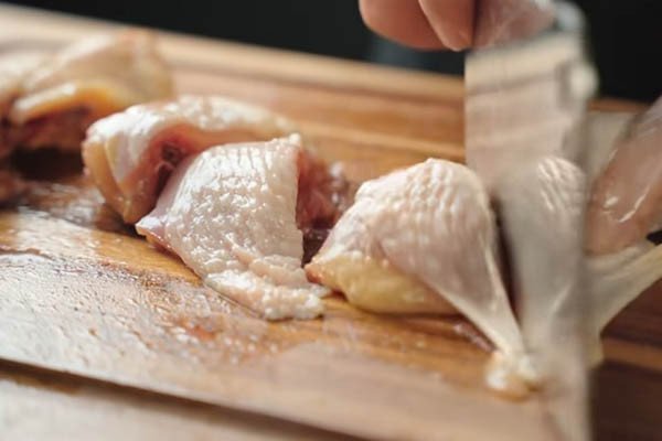 Chặt gà thành miếng vừa ăn để chuẩn bị nấu món cà ri gà
