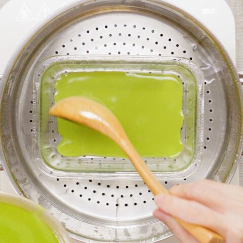 Chén bột bánh da lợn màu xanh chuẩn bị đổ vào khuôn đã quét dầu ăn để bắt đầu công đoạn hấp