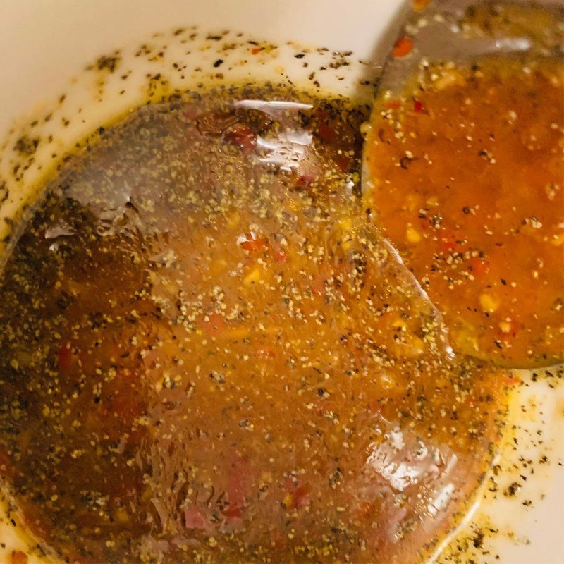 Chén nước sốt sa tế đã pha chế với màu sắc hấp dẫn, chuẩn bị cho món mực xào thơm ngon.