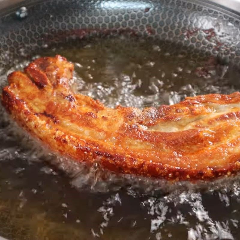Chiên thịt ba chỉ quay bằng chảo ngập dầu ở nhiệt độ phù hợp để da heo nổ giòn