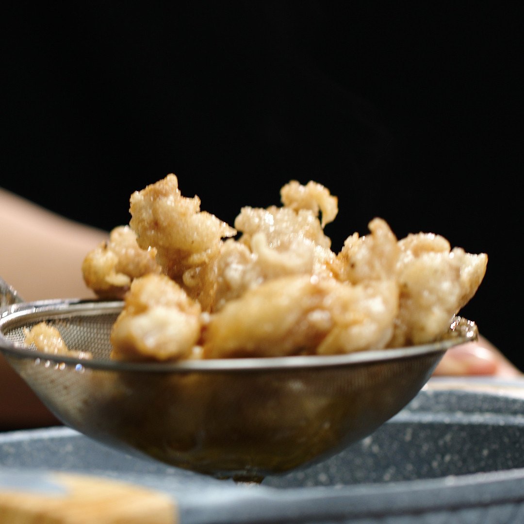 Chiên thịt heo trong dầu nóng để tạo lớp vỏ giòn rụm theo cách làm thịt heo chiên xù Hàn Quốc