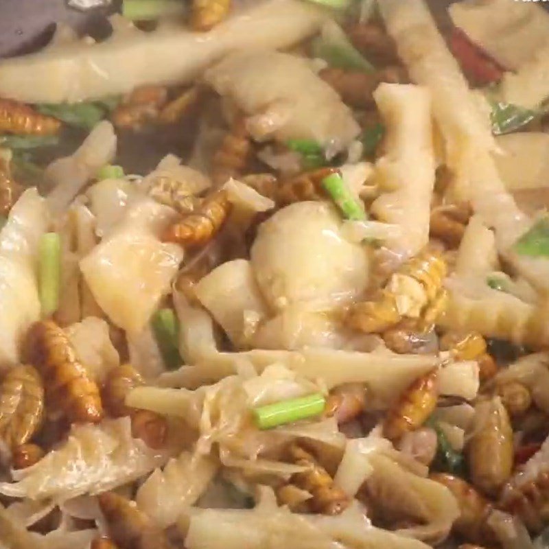 Cho ngò gai và ớt vào xào cùng nhộng ong và măng