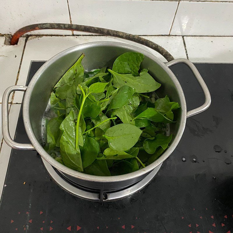Cho rau mồng tơi vào nồi canh hến