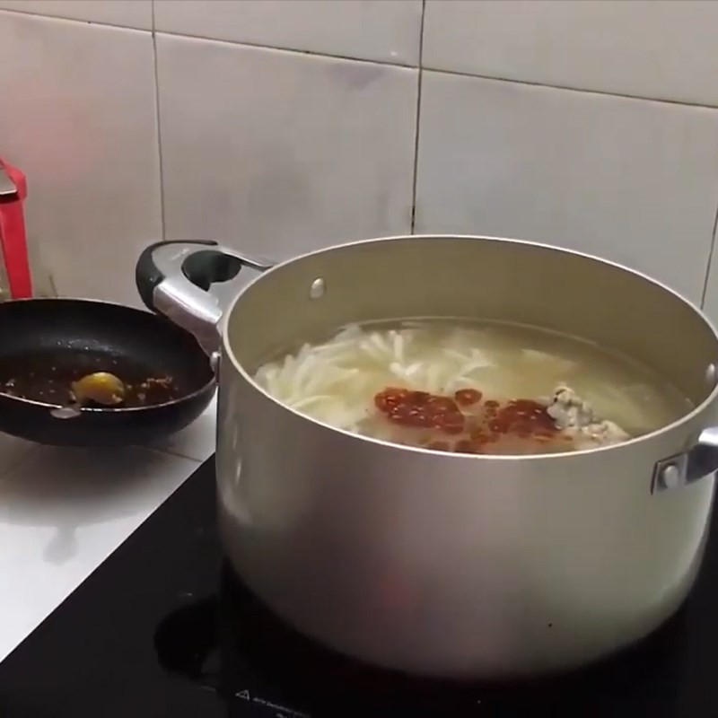 Cho sợi bánh canh đã luộc vào nồi nước dùng xương heo đang sôi