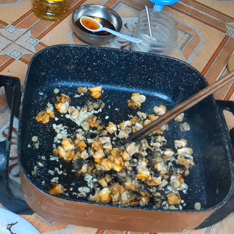 Cho thịt ốc bươu vào chảo, bắt đầu xào săn cùng gia vị