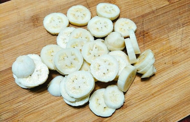 Chuối cắt lát để chuẩn bị làm bánh chuối nướng bằng nồi cơm điện, thể hiện sự tươi ngon và sẵn sàng cho công đoạn sơ chế.