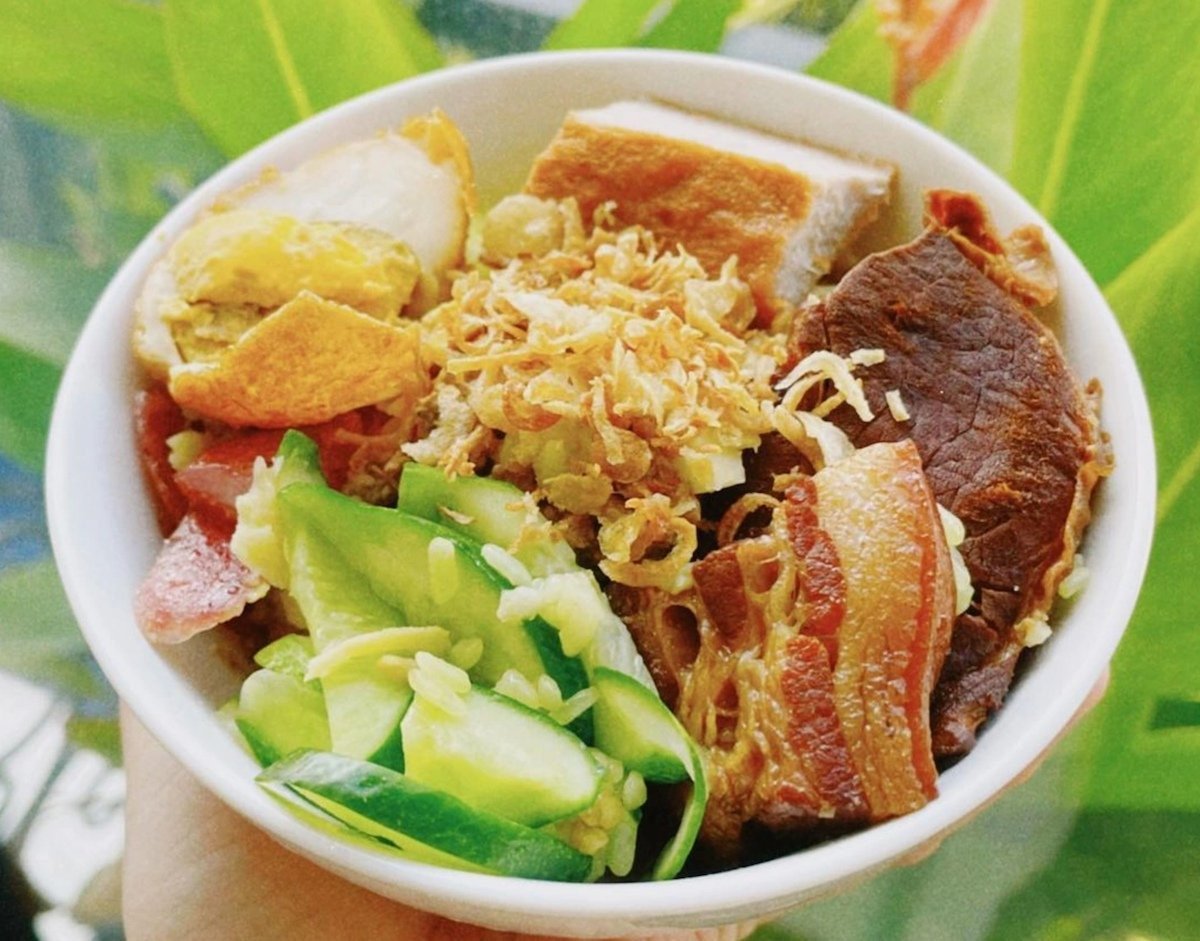 Cơm nếp đậm đà kết hợp cùng thịt kho trứng, giò chả và dưa chua, tạo nên bữa ăn chuẩn vị Việt.