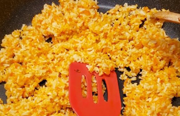 Cơm vàng ươm đang được chiên cùng gia vị, chuẩn bị cho món cơm gà xối mỡ hấp dẫn