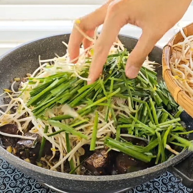 Đảo nhanh tay giá hẹ và ớt sau khi huyết đã thấm vị