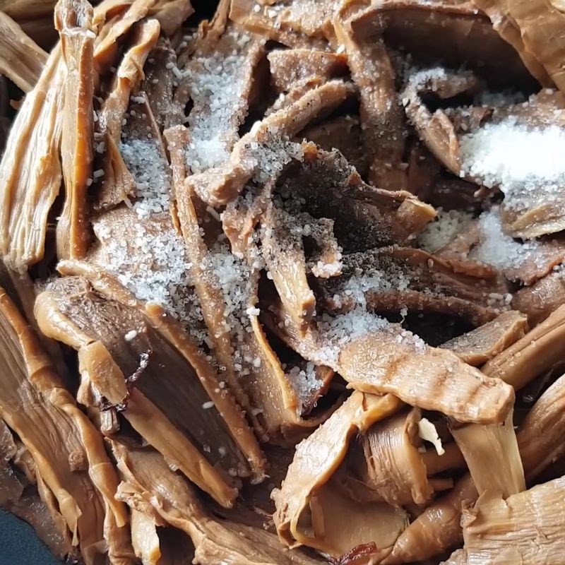 Đầu bếp đang nêm nếm gia vị cho măng khô xào, bước quan trọng trong cách nấu miến gà măng khô