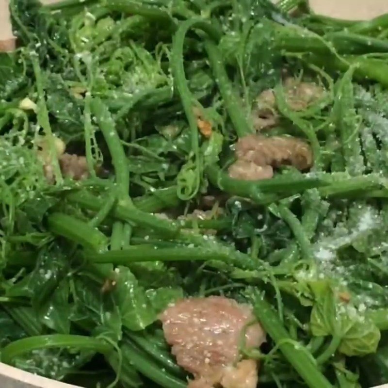 Đầu bếp đang nêm nếm gia vị cho món ngọn su su xào thịt heo, đảm bảo hương vị vừa miệng