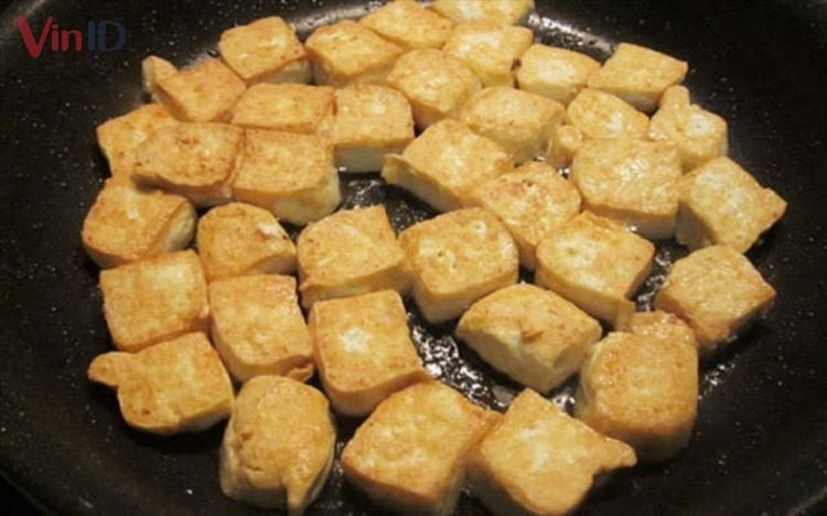 Đậu hũ đang được chiên vàng đều hai mặt trước khi kho thịt