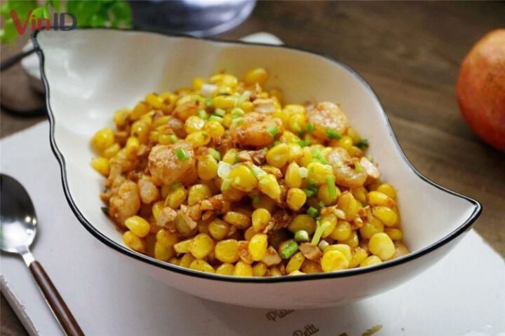 Đĩa bắp xào bơ tép thơm lừng, hạt bắp vàng óng trộn cùng tép sấy giòn rụm, điểm xuyết hành lá xanh tươi.