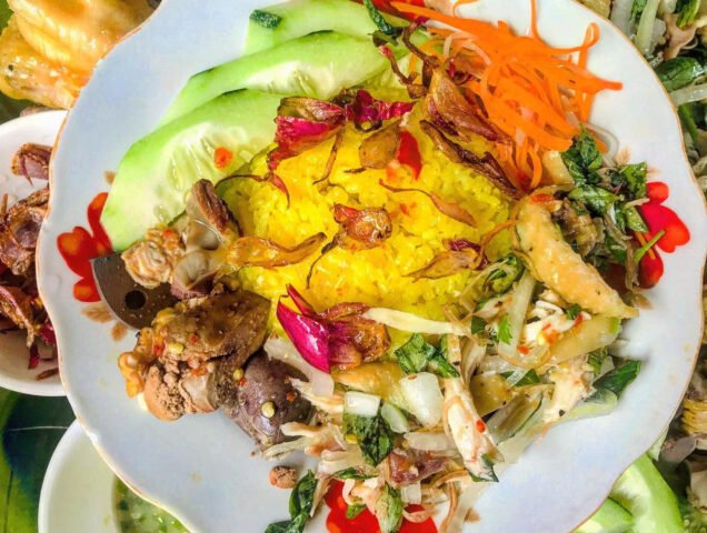 Đĩa cơm gà màu vàng ươm, thịt gà xé đậm đà, trang trí rau thơm hấp dẫn