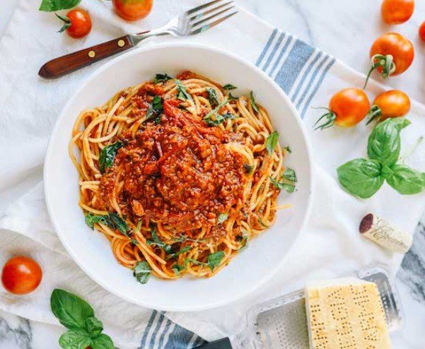 Đĩa mì xào thịt bò băm sốt cà chua đậm đà, trang trí thêm ngò rí và tiêu xay