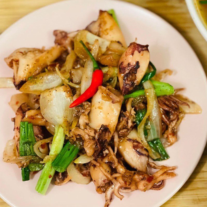 Đĩa mực xào sa tế thành phẩm với màu sắc bắt mắt, rắc tiêu và trang trí đẹp mắt.