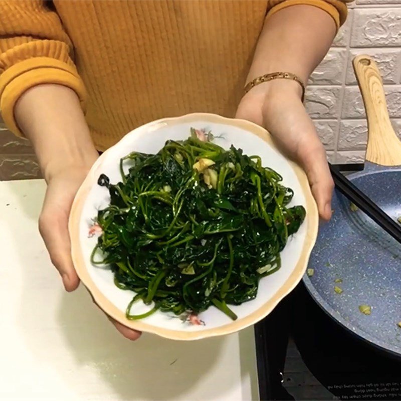 Đĩa rau khoai lang xào tỏi xanh mướt, thơm ngon trên bàn ăn