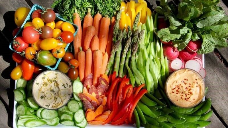 Đĩa rau xanh tươi mát và các loại trái cây cần thiết để cân bằng dinh dưỡng khi ăn bánh ướt