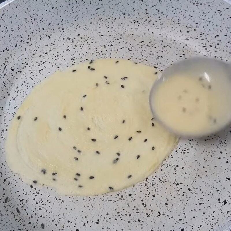 Đổ lớp bột mỏng vào chảo chống dính đang nóng để thực hiện cách làm bánh kẹp cuốn.