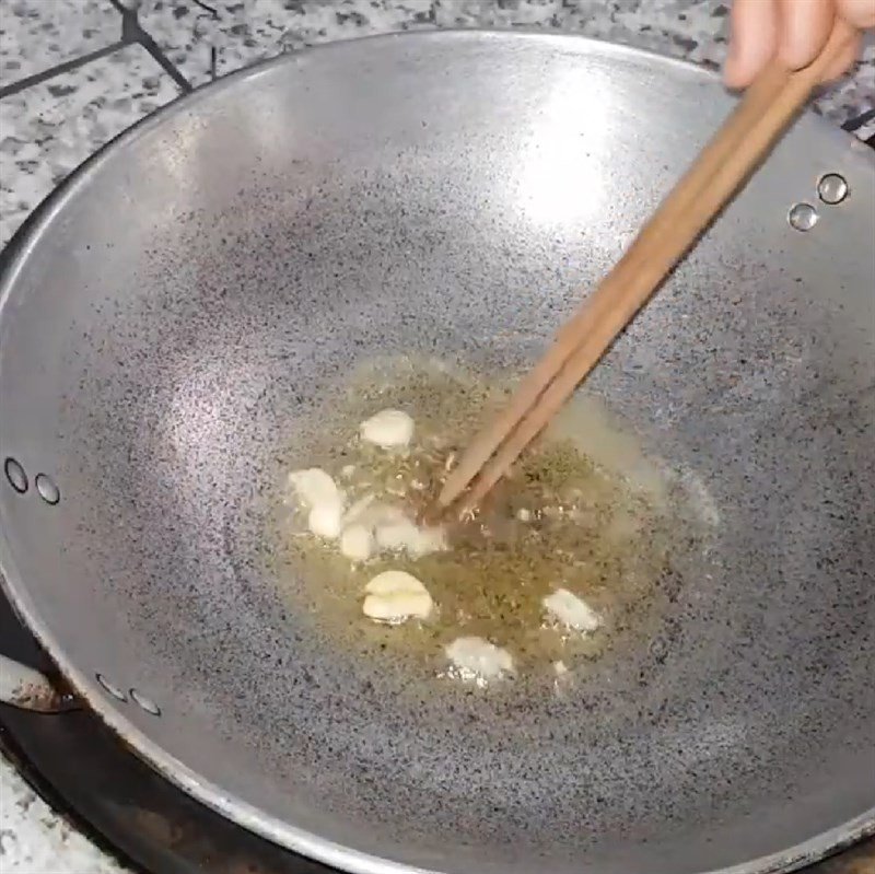 Dứa đang được xào trên chảo với tỏi thơm lừng