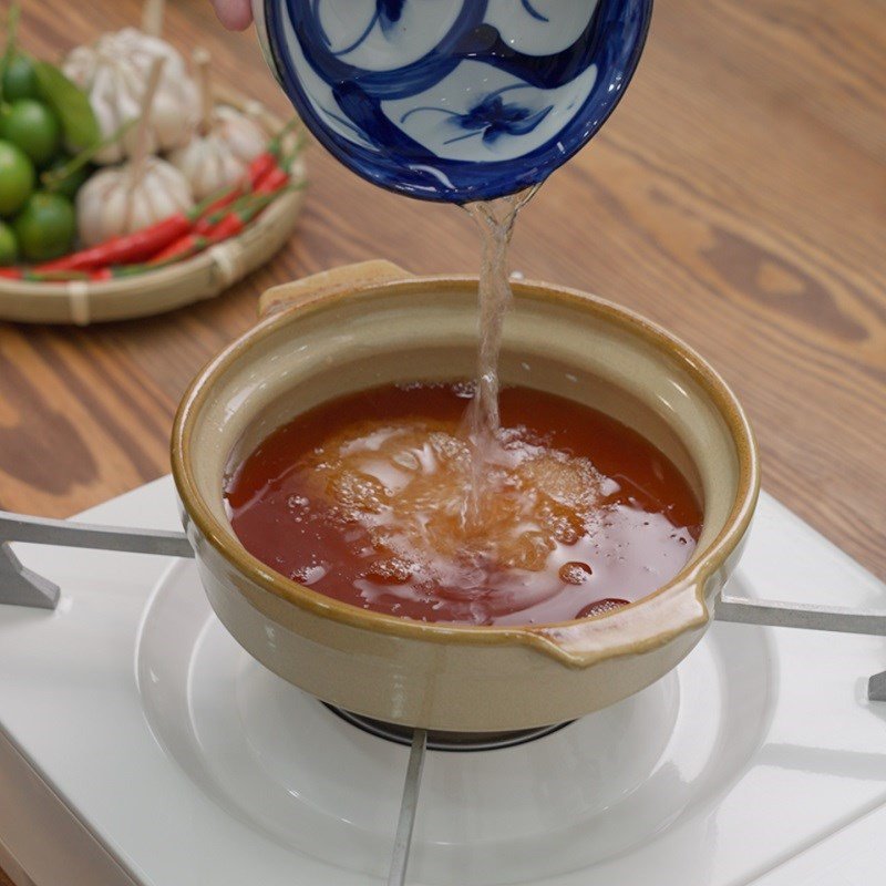 Đun sôi nước mắm và đường trên bếp nhỏ lửa