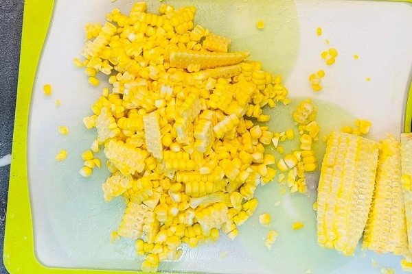 Dùng dao gọt hạt ngô tươi để chuẩn bị làm sữa ngô