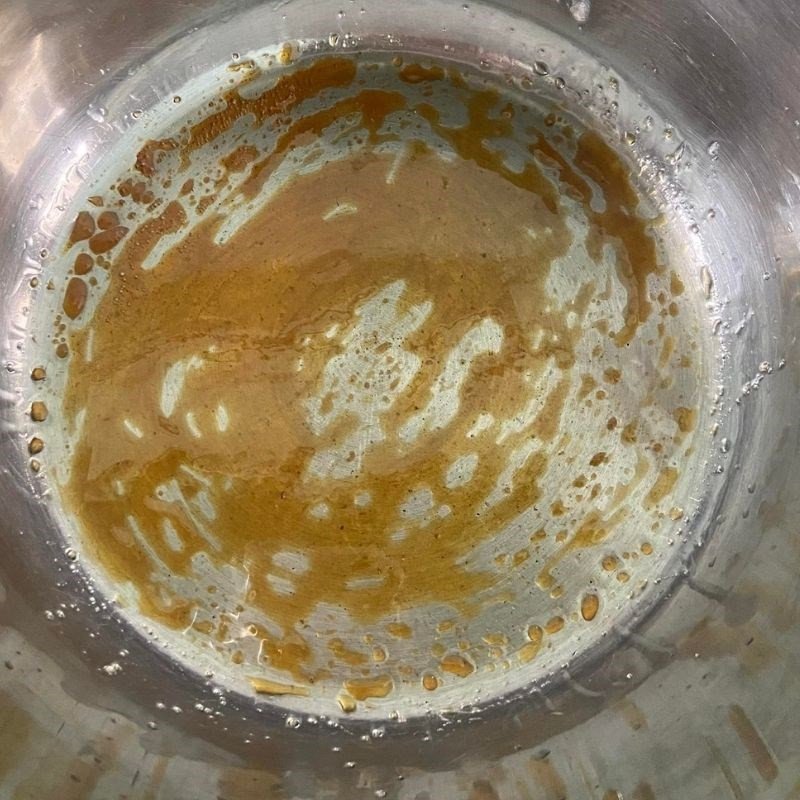 Đường được đun trên chảo với lửa nhỏ, đang dần chuyển sang màu caramel cánh gián đẹp mắt, là bước quan trọng tạo nên màu sắc hấp dẫn cho món thịt rim mặn ngọt