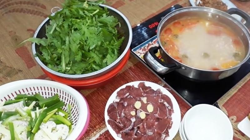 Gia đình quây quần thưởng thức món lẩu trâu nhúng mẻ ấm cúng