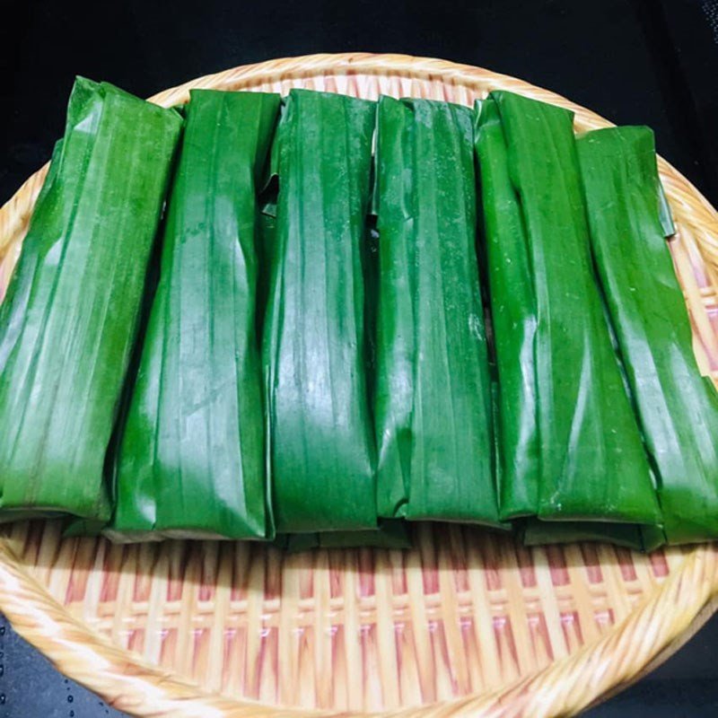 Gói bánh răng bừa cẩn thận với nhân và bột trên lá chuối