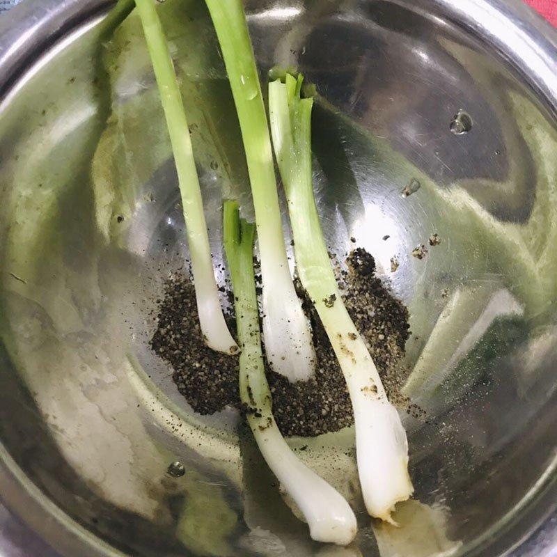 Hành lá và tiêu xay đang được giã nhuyễn, gia vị quan trọng cho món canh rau má thịt băm.