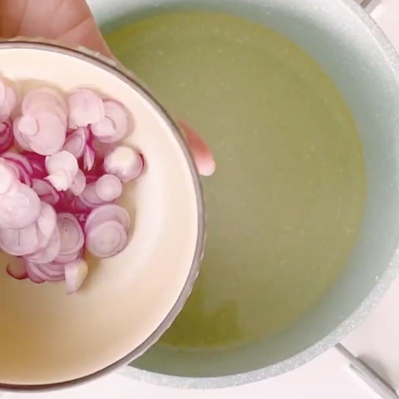 Hành tím đang được phi thơm trên chảo dầu nóng