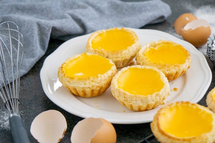 Hình ảnh cận cảnh những chiếc bánh tart trứng vừa ra lò, lớp vỏ giòn rụm.