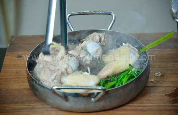 Hình ảnh chần xương gà và xương heo qua nước sôi, bước quan trọng trong cách nấu lẩu cua đồng hải sản ngon nhất.