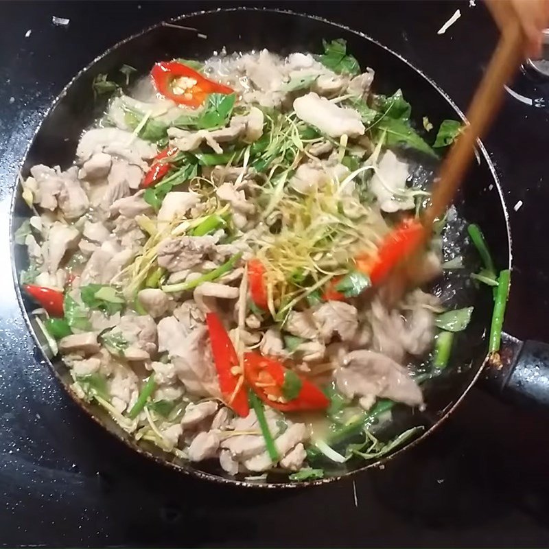 Hoàn thành món ngan xào lăn với hành lá và rau răm