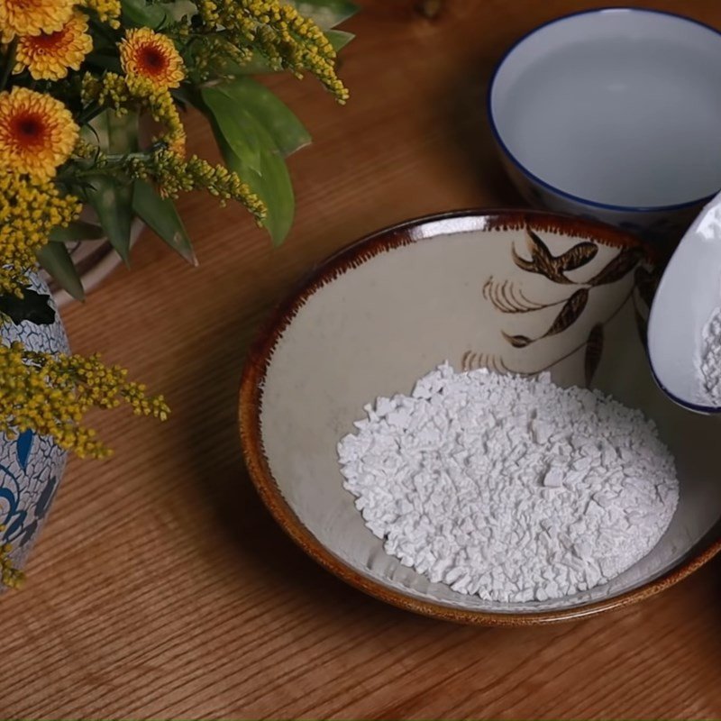 Hỗn hợp bột sắn dây và bột năng đang được khuấy đều với nước trong một bát