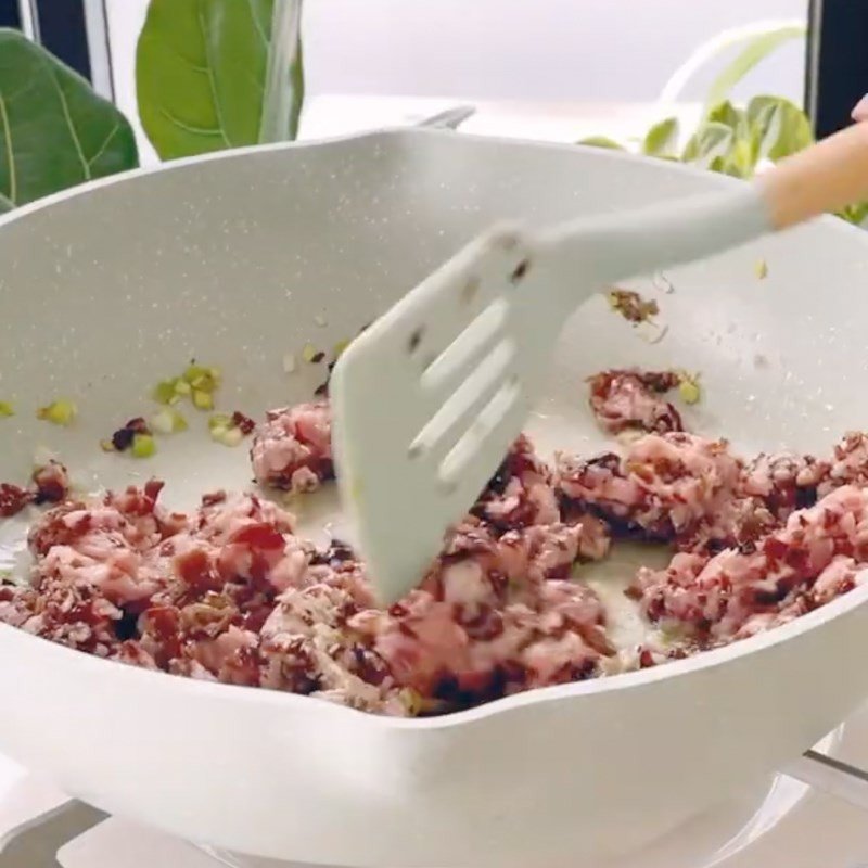 Hỗn hợp thịt heo xay và nấm mèo băm nhuyễn đang được xào chín trong chảo